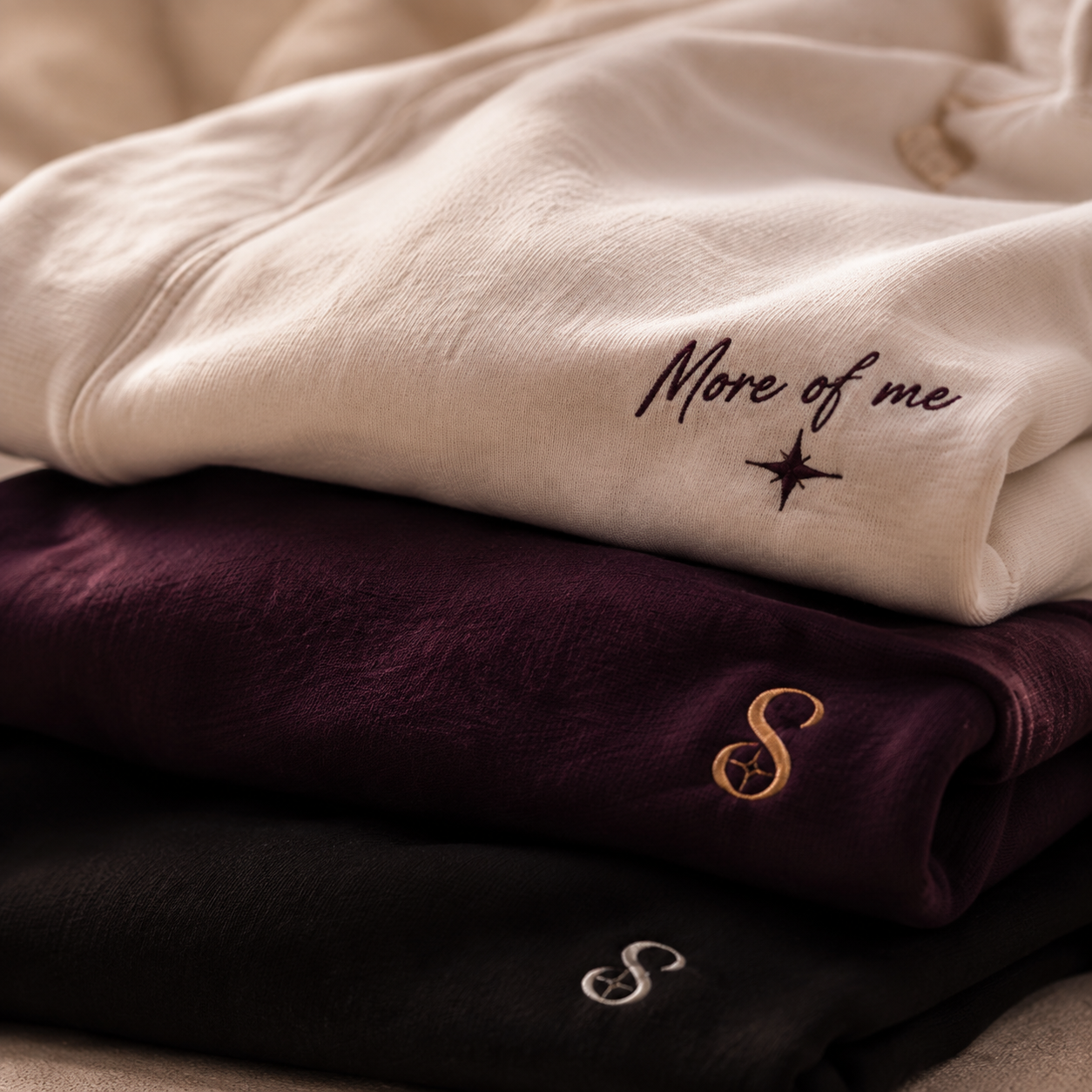 Concept: a complete stack of ivory, plum and onyx sweatshirts with expressive details.